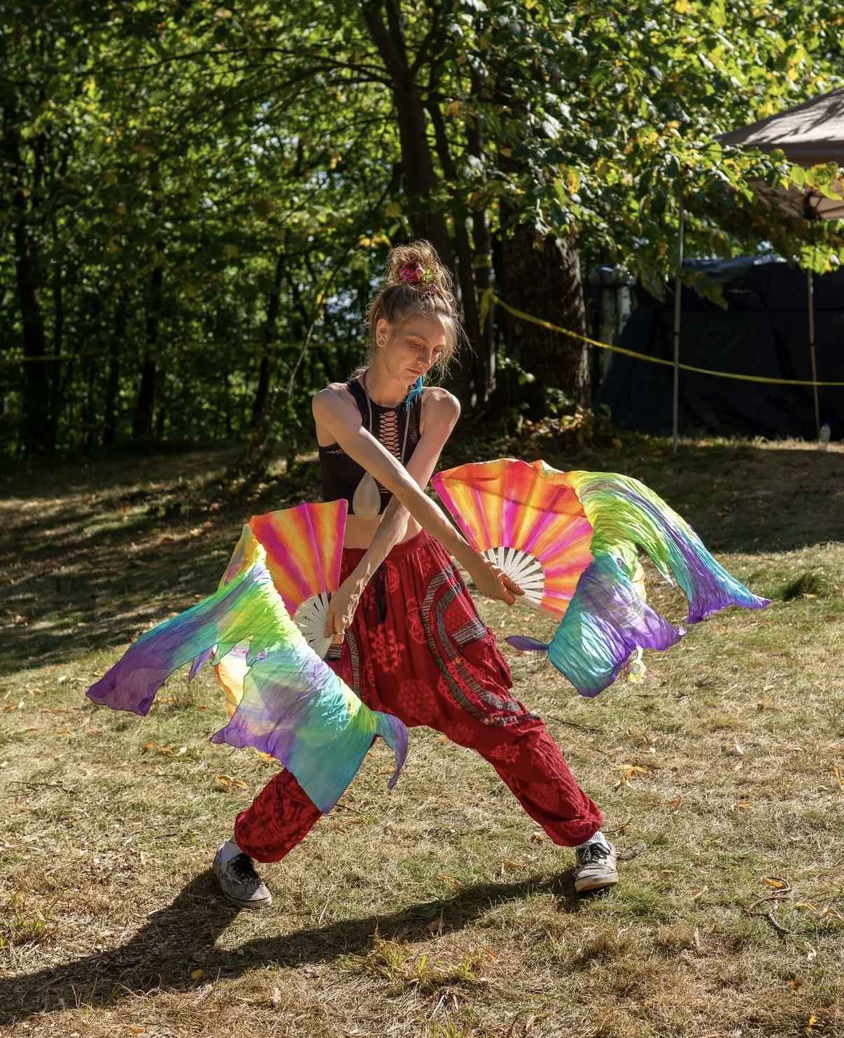 A performer holding a pair of flow fans